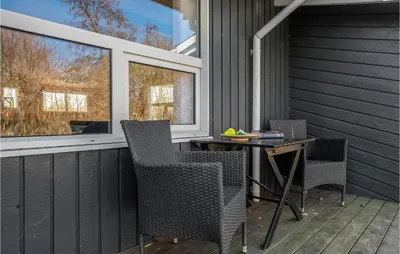 a patio with chairs and a table and windows at Cozy Home In Roslev With Wifi in Roslev