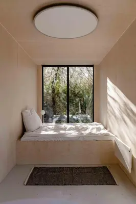a bed in a room with a large window at Containerhus 18b in Harboør