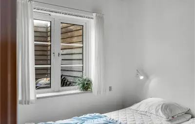 a bedroom with a bed and a window at Two-Bedroom Apartment In Lemvig in Lemvig