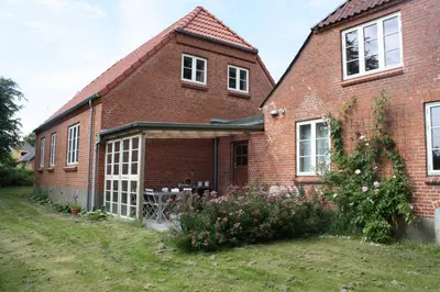 a brick house with a garden in front of it at Rosengave Annekset in Nykøbing Mors