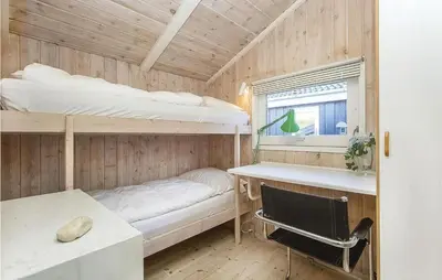 a small room with two bunk beds and a window at Beautiful Home In Blokhus With Wifi in Blokhus