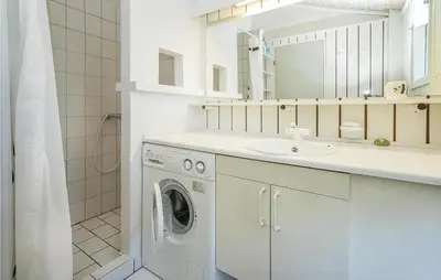 a white bathroom with a washing machine and a sink at Beautiful Home In Blokhus With Wifi in Blokhus