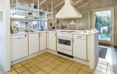 a kitchen with white cabinets and white appliances at Beautiful Home In Blokhus With Wifi in Blokhus