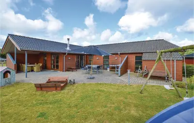 a home with a patio and a house at Three-Bedroom Holiday Home In Vinderup in Vinderup
