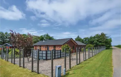 a fence in front of a small house at Three-Bedroom Holiday Home In Vinderup in Vinderup