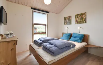 a bedroom with a bed with blue pillows on it at Three-Bedroom Holiday Home In Vinderup in Vinderup