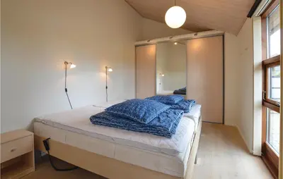 a bedroom with a bed with a large mirror at Three-Bedroom Holiday Home In Vinderup in Vinderup