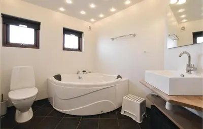 a bathroom with a tub and a toilet and a sink at Three-Bedroom Holiday Home In Vinderup in Vinderup