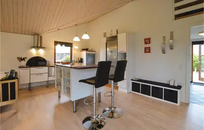 a kitchen with a counter and two chairs in a room at Three-Bedroom Holiday Home In Vinderup in Vinderup