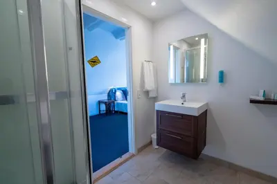a bathroom with a sink and a shower with a mirror at Klitmøller Hotel in Klitmøller