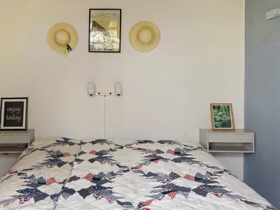 a bedroom with a bed with a quilt on it at 5 person holiday home in Vinderup-By Traum in Vinderup