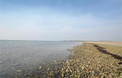 a beach with rocks and water on it at Three-Bedroom Holiday Home In Hurup Thy in Sindrup