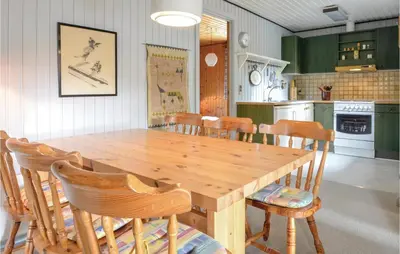 a wooden table and chairs in a kitchen at Three-Bedroom Holiday Home In Hurup Thy in Sindrup