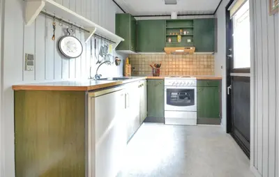 a kitchen with green cabinets and a white oven at Three-Bedroom Holiday Home In Hurup Thy in Sindrup