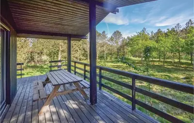 a wooden porch with a picnic bench on a deck at Three-Bedroom Holiday Home In Hurup Thy in Sindrup