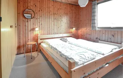 a bedroom with a large bed in a wooden wall at Three-Bedroom Holiday Home In Hurup Thy in Sindrup