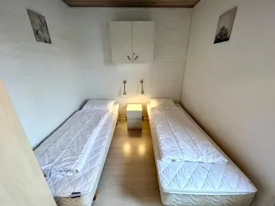 a room with two beds in a room with at Agger Tange Feriecenter lejligheder - 100 m fra Vesterhavet in Vestervig