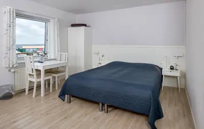 a bedroom with a bed and a table and a window at Hvalpsund Færgekro in Hvalpsund