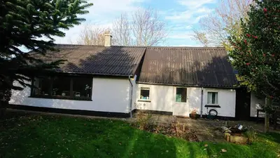 a white house with a black roof at B&B Hesselbjerg in Hesselbjerg