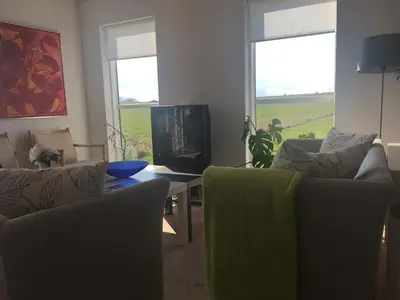 a living room with two couches and a tv at B&B Hesselbjerg in Hesselbjerg