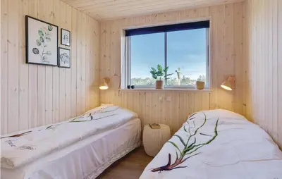 two beds in a room with a window at 8 Bedroom Awesome Home In Thisted in Thisted