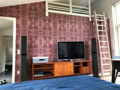 a bedroom with a tv and a brick wall at Fly B&B in Skive