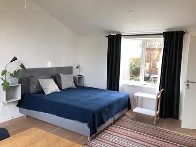 a bedroom with a blue bed and a window at Fly B&B in Skive