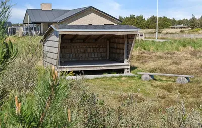 a house with a dog house in a field at Nice Home In Thisted With Sauna in Thisted