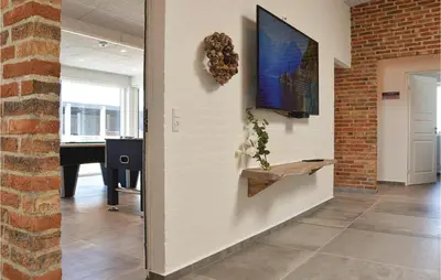 a hallway with a wall with a tv and a table at Nice Home In Thisted With Sauna in Thisted