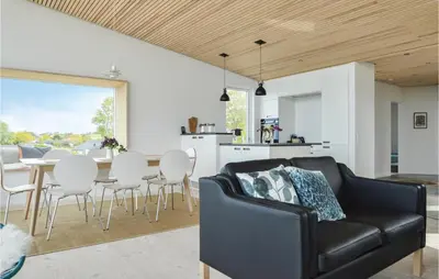 a living room with a black couch and a table at Three-Bedroom Holiday Home In Farso in Farsø