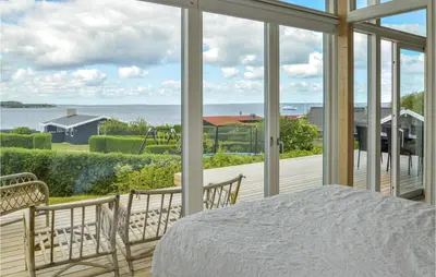 a bedroom with a bed and a view of the ocean at Three-Bedroom Holiday Home In Farso in Farsø