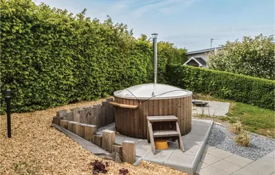 a hot tub with a stool in a garden at Three-Bedroom Holiday Home In Farso in Farsø