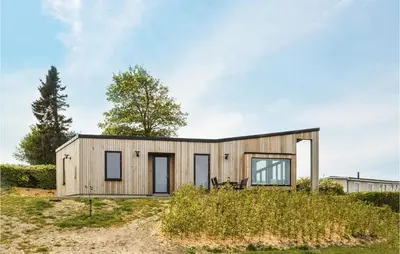 a small wooden house on top of a field at Three-Bedroom Holiday Home In Farso in Farsø