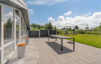 a patio with a table and a playground at Four-Bedroom Holiday Home In Fjerritslev in Fjerritslev