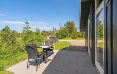 a patio with two chairs and a table on the side of a house at Four-Bedroom Holiday Home In Fjerritslev in Fjerritslev