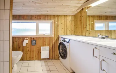 a bathroom with a washing machine and a sink at Four-Bedroom Holiday Home In Fjerritslev in Fjerritslev