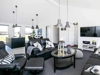 a living room with a couch and a table at Modern Retreat with Spa - By Traum Ferienwohnungen in Løkken