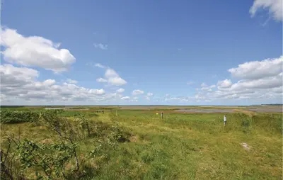 a field of grass with a blue sky and clouds at Two-Bedroom Holiday Home In Spottrup in Spottrup