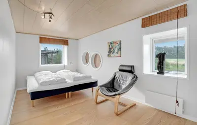 a bedroom with a bed and a chair in it at Two-Bedroom Holiday Home In Spottrup in Spottrup