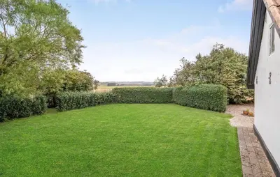 a garden with green grass and a hedge at Two-Bedroom Holiday Home In Spottrup in Spottrup