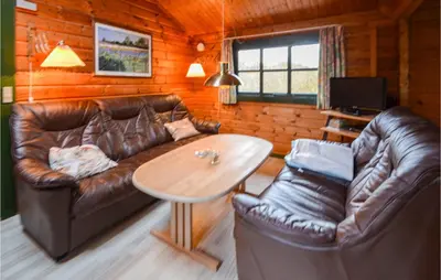 a living room with a leather couch and a table at Three-Bedroom Holiday Home In Roslev in Roslev