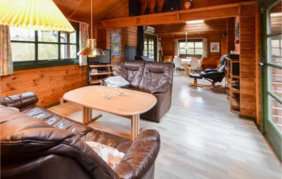 a living room with leather furniture and a table at Three-Bedroom Holiday Home In Roslev in Roslev