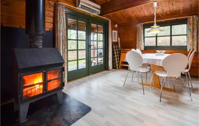 a dining room with a fireplace and a table and chairs at Three-Bedroom Holiday Home In Roslev in Roslev