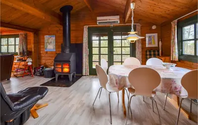 a dining room with a table and chairs and a stove at Three-Bedroom Holiday Home In Roslev in Roslev