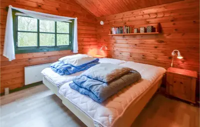 a bedroom with a bed in a log cabin at Three-Bedroom Holiday Home In Roslev in Roslev