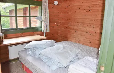 a bedroom with a bed with pillows and a window at Three-Bedroom Holiday Home In Roslev in Roslev
