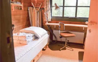 a bedroom with a bed and a desk and a chair at Three-Bedroom Holiday Home In Roslev in Roslev