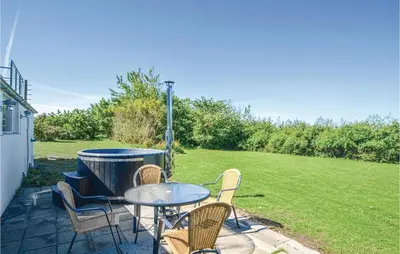 a patio with a table and chairs and a field at Three-Bedroom Holiday Home In Vinderup in Vinderup