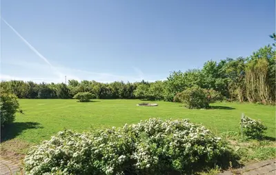 a large field of grass with a bench in it at Three-Bedroom Holiday Home In Vinderup in Vinderup