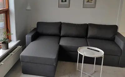 a living room with a couch and a table at Feriehus Thy - I hjertet af Thy in Thisted